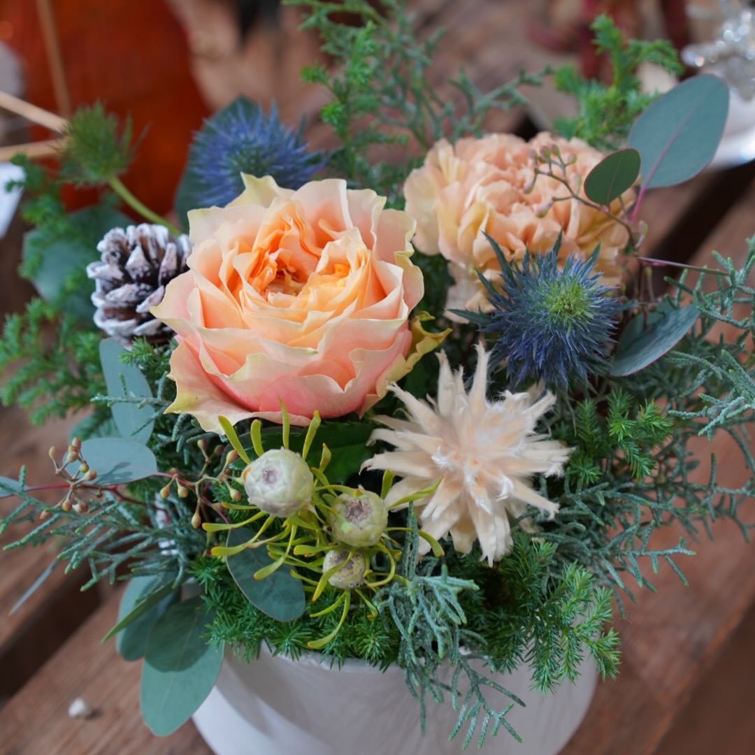 淡いオレンジカラーが優しげなクリスマスのアレンジメントドライのアクセントとの組み合わせも素敵に仕上がります。